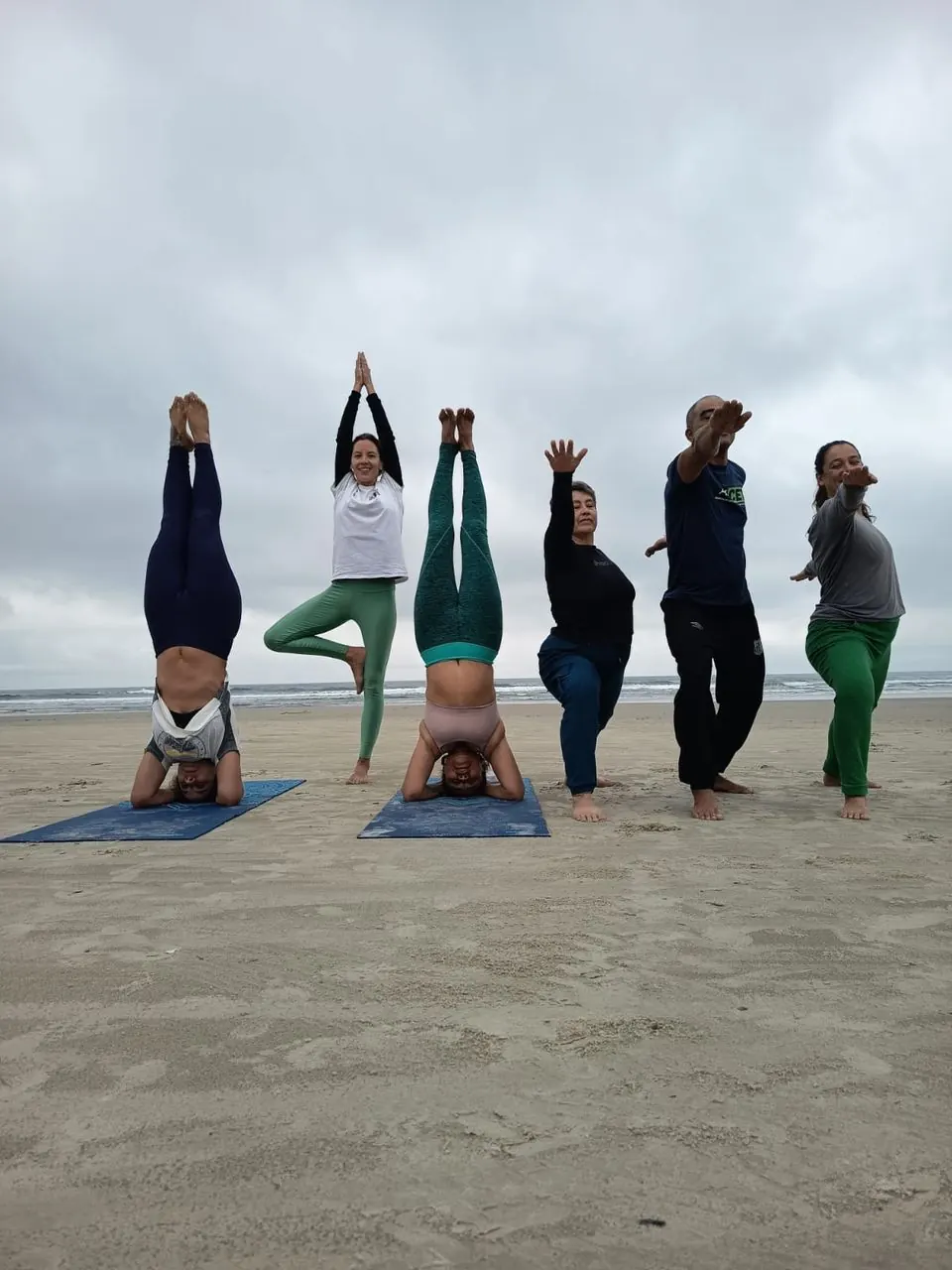 Grupo praticando yoga na praia