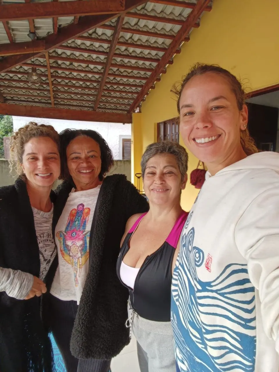 Quatro mulheres sorrindo juntas na varanda do instituto